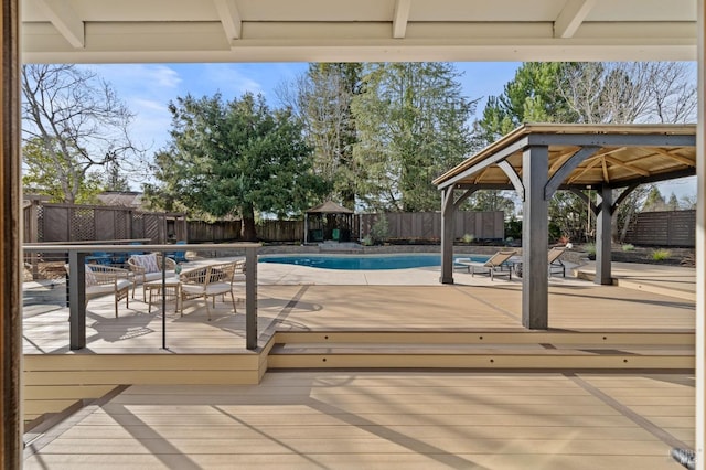 view of swimming pool featuring a deck, a gazebo, and a fenced backyard