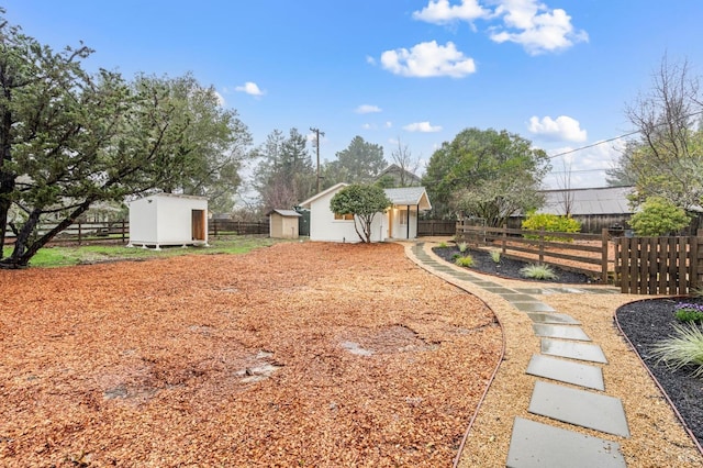 view of yard featuring an outbuilding, fence, and a storage shed