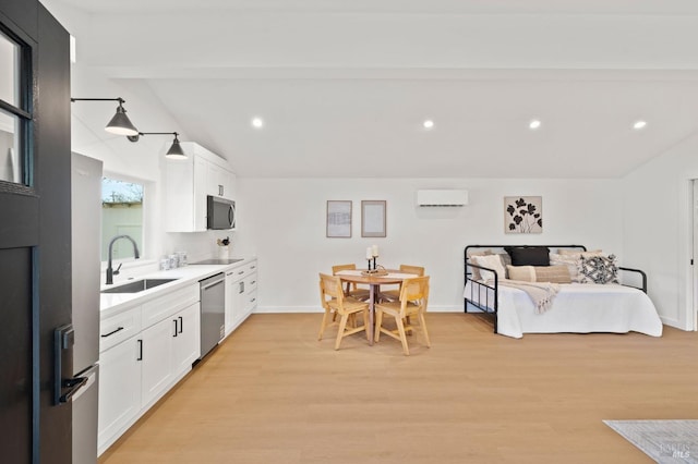 kitchen with stainless steel appliances, a sink, light countertops, and white cabinets