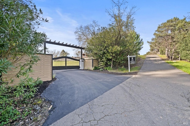 view of street with a gate and aphalt driveway