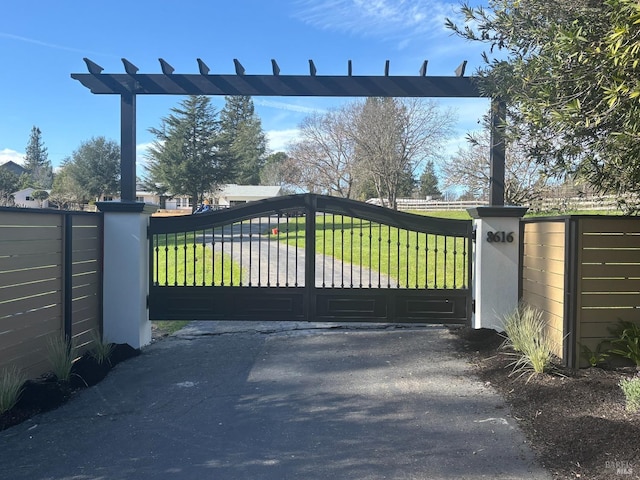 view of gate with a lawn