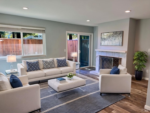 living room featuring a tiled fireplace and hardwood / wood-style flooring