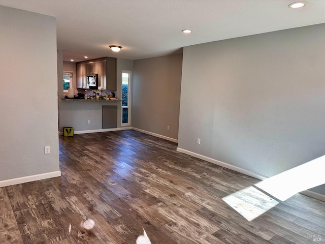 unfurnished living room with dark wood-type flooring