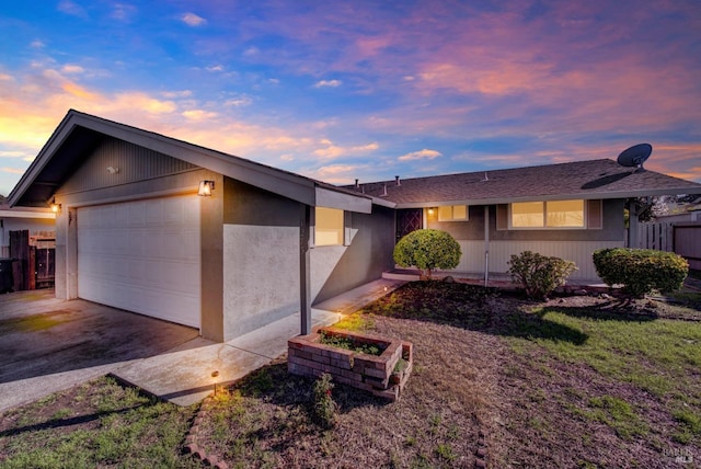 ranch-style home with a garage, driveway, and fence