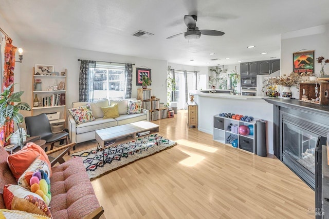 living room featuring ceiling fan and light hardwood / wood-style floors