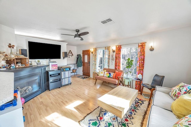 living room featuring ceiling fan and light hardwood / wood-style flooring