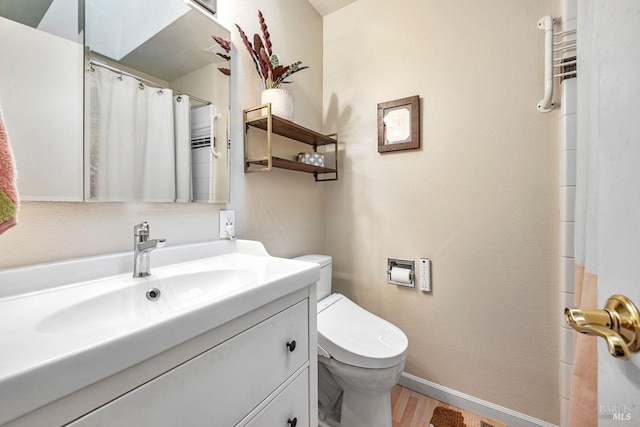 bathroom with hardwood / wood-style flooring, vanity, and toilet