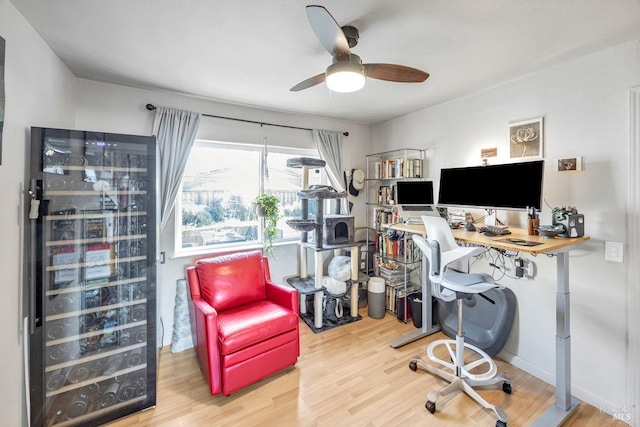 office with wine cooler, wood-type flooring, and ceiling fan