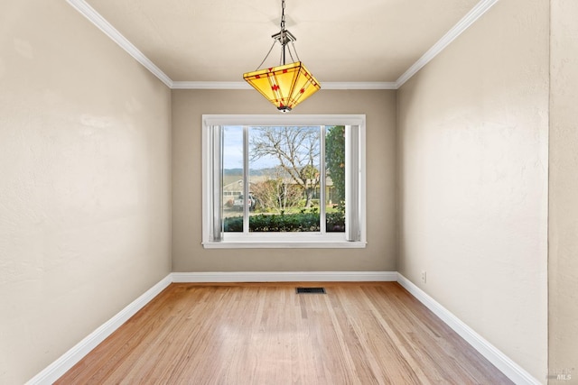 unfurnished dining area with crown molding and light wood-type flooring