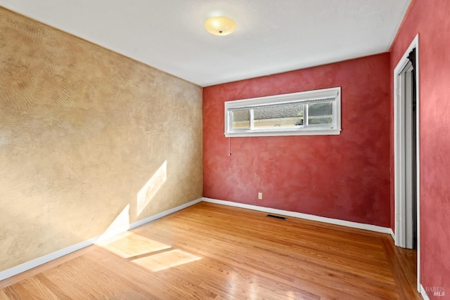 unfurnished room with hardwood / wood-style floors