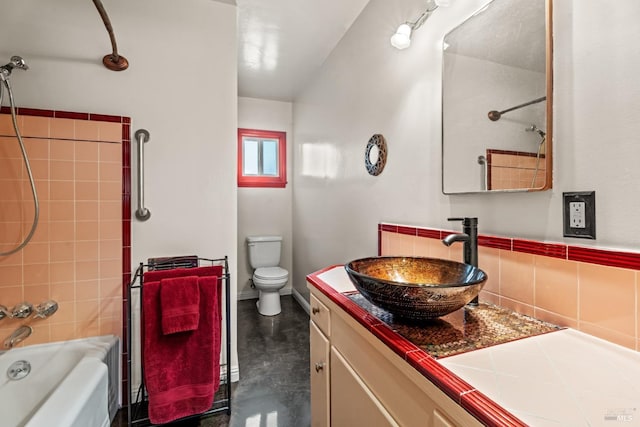 full bathroom with vanity, concrete flooring, toilet, and washtub / shower combination