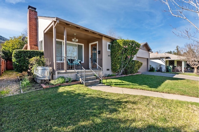 view of front of home with a garage, a front yard, and covered porch