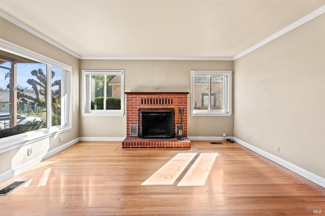 unfurnished living room with crown molding, a fireplace, and light wood-type flooring