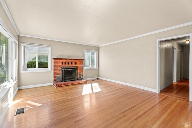 unfurnished living room featuring a brick fireplace, hardwood / wood-style flooring, and a wealth of natural light