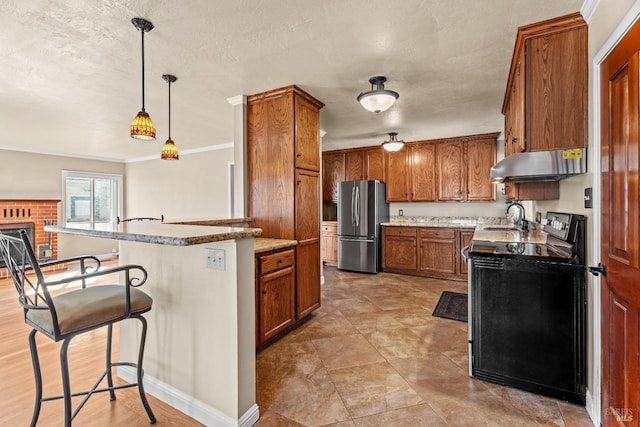 kitchen featuring stainless steel fridge, a breakfast bar, black range with electric stovetop, hanging light fixtures, and exhaust hood