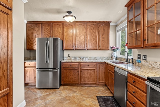 kitchen featuring light stone counters, stainless steel appliances, crown molding, and sink