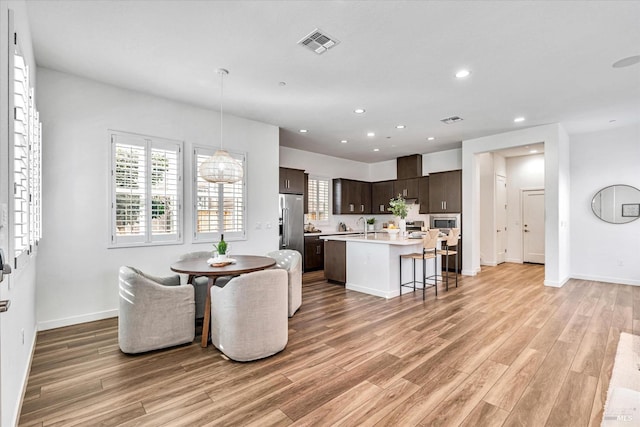 dining space featuring light wood-type flooring, baseboards, visible vents, and recessed lighting