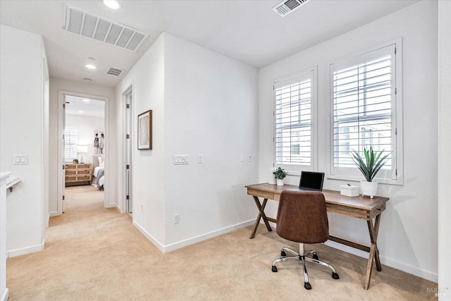 office space featuring light colored carpet, visible vents, and baseboards