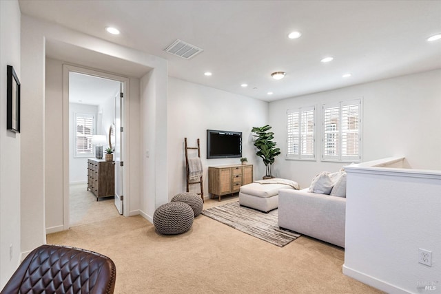 living area featuring baseboards, recessed lighting, visible vents, and light colored carpet