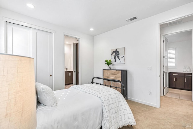 bedroom featuring light colored carpet, connected bathroom, visible vents, and baseboards