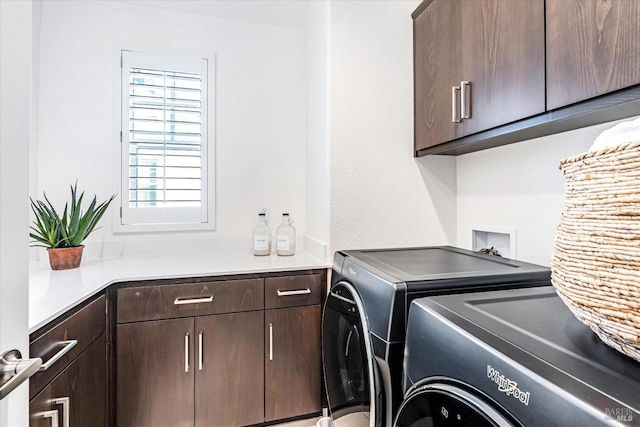 laundry room with washing machine and clothes dryer and cabinet space