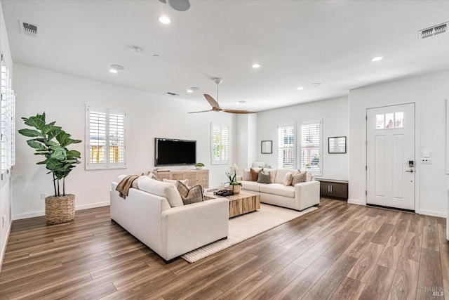 living room featuring visible vents, wood finished floors, and recessed lighting