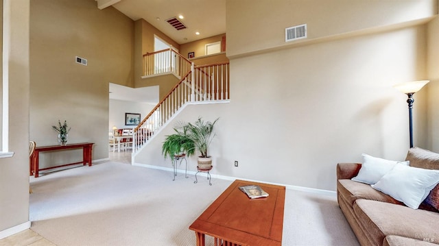 living room featuring carpet flooring and a towering ceiling