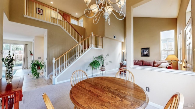 carpeted dining area featuring a towering ceiling and a chandelier