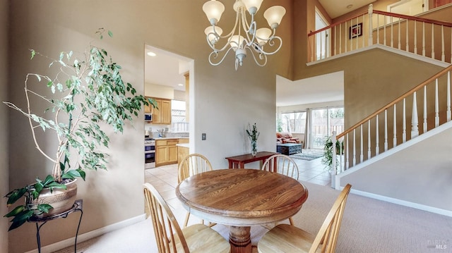 carpeted dining space featuring a high ceiling and an inviting chandelier