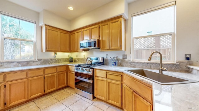 kitchen featuring sink, light tile patterned floors, and appliances with stainless steel finishes