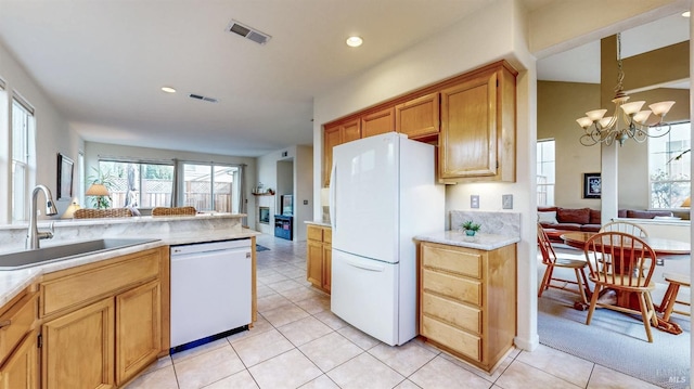 kitchen with pendant lighting, sink, white appliances, light tile patterned floors, and a chandelier