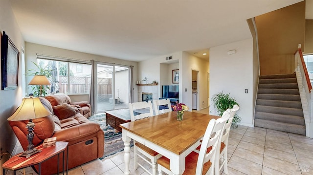 dining room with light tile patterned flooring and a tile fireplace