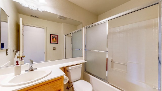 full bathroom with enclosed tub / shower combo, vanity, and toilet