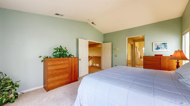 carpeted bedroom with vaulted ceiling and ensuite bathroom