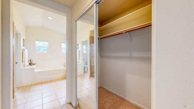 interior space featuring tile patterned flooring and a tub to relax in