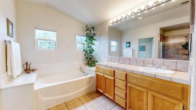 bathroom featuring tile patterned flooring, vaulted ceiling, plenty of natural light, and vanity