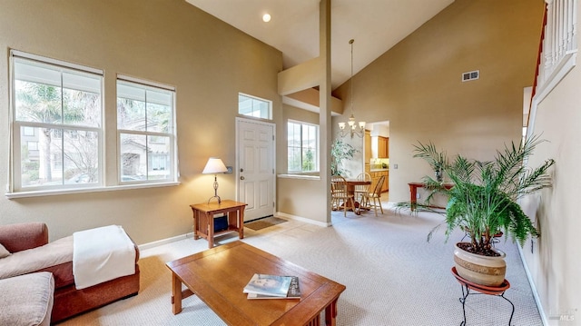 carpeted living room featuring a chandelier and high vaulted ceiling