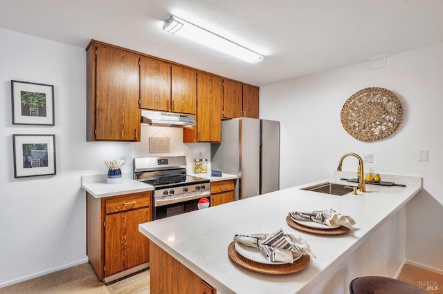 kitchen with sink, a kitchen breakfast bar, stainless steel appliances, and kitchen peninsula