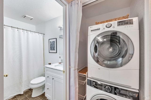 laundry area with stacked washer / dryer