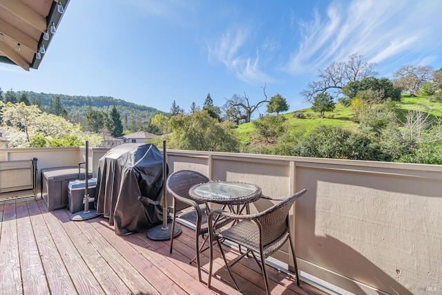 wooden terrace with a hot tub and grilling area