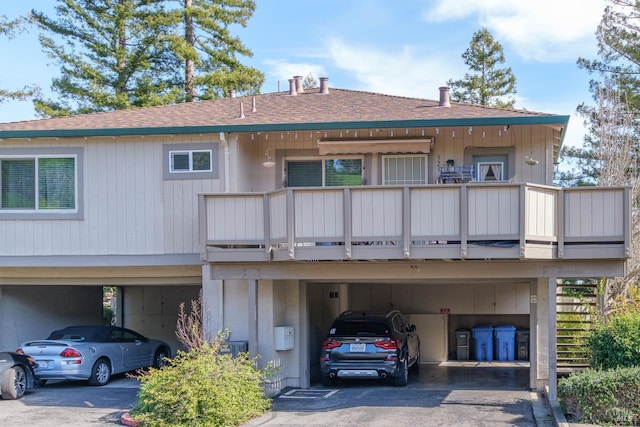 back of property featuring a balcony and a carport