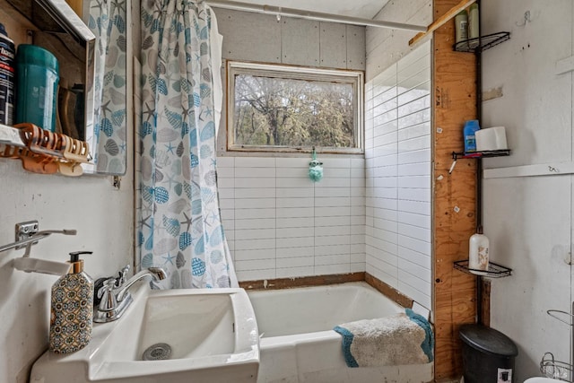 bathroom with shower / bathtub combination with curtain and sink