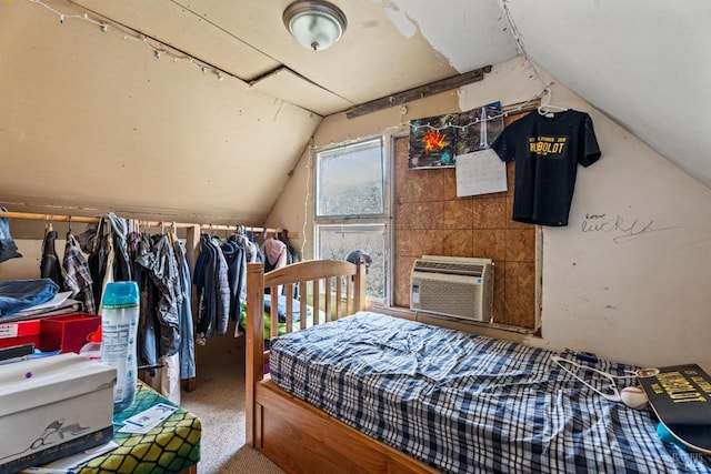 bedroom featuring vaulted ceiling, carpet, and a wall unit AC