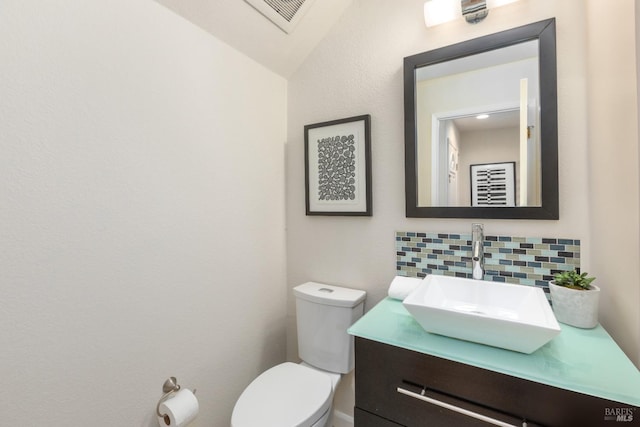 bathroom featuring tasteful backsplash, vanity, and toilet