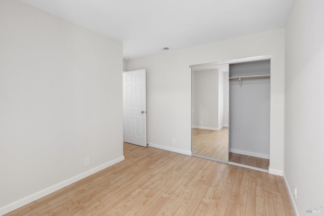 unfurnished bedroom featuring a closet and light hardwood / wood-style flooring