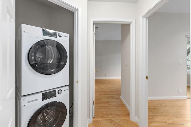 washroom featuring stacked washing maching and dryer and light hardwood / wood-style floors