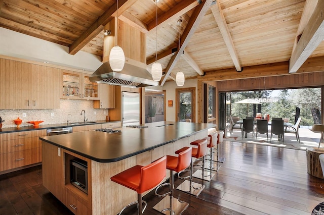 kitchen with a spacious island, sink, decorative light fixtures, a kitchen breakfast bar, and decorative backsplash