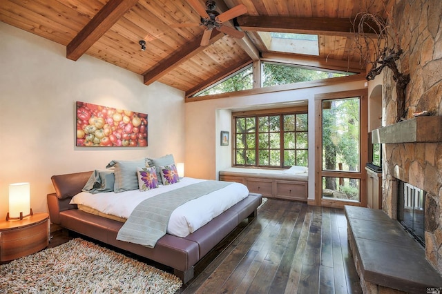 bedroom featuring wood ceiling, a stone fireplace, lofted ceiling with skylight, and dark hardwood / wood-style floors