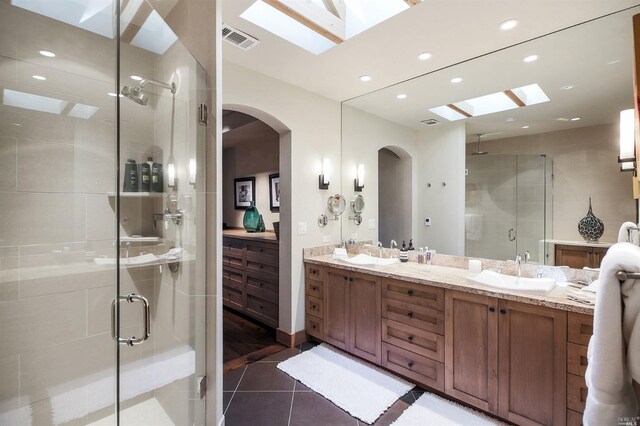 bathroom featuring vanity, a shower with shower door, and tile patterned floors