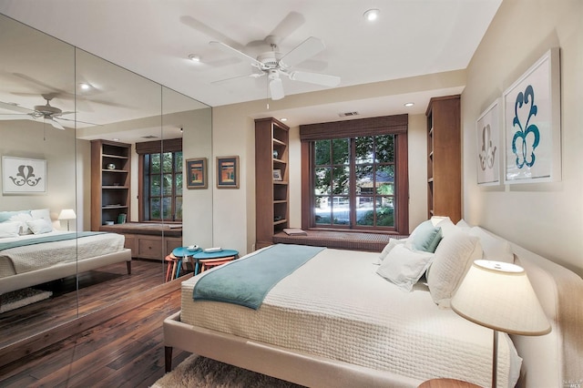 bedroom featuring multiple windows, dark wood-type flooring, a closet, and ceiling fan